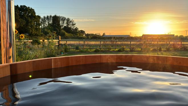 A photograph taken from my hot tub, showing the sun setting over the
countryside and an adjacent farm.
