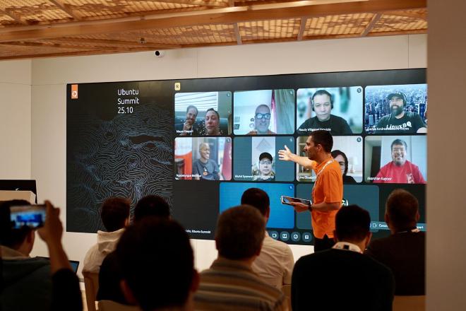 A photograph of a presenter showing online audience
participation at the Ubuntu Summit 25.10